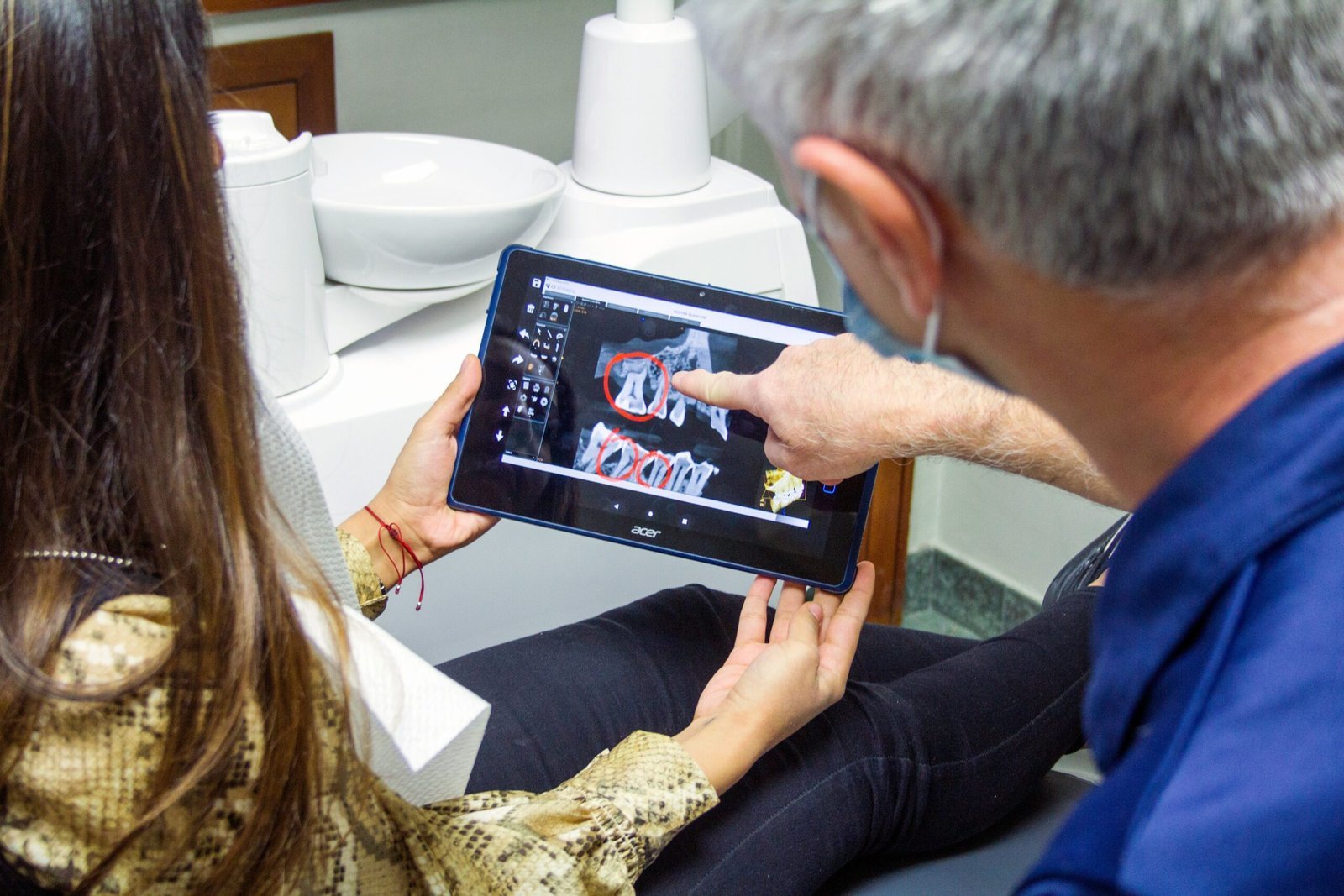 woman in blue denim jeans holding black tablet computer